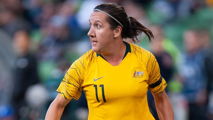 A female Australia football international looks to her right during a match against Argentina.