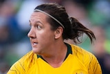 A female Australia football international looks to her right during a match against Argentina.