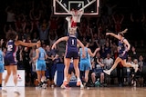 Players jump for joy after a last-second winning basket in the WNBL finals series.