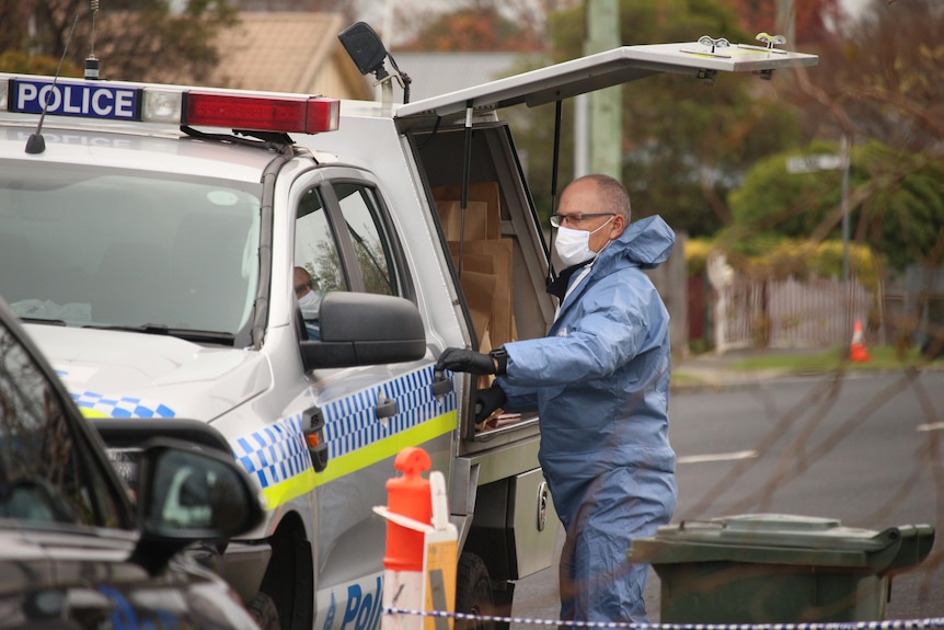 Police remove evidence from one of the three crime scenes related to a stabbing death in Ulverstone