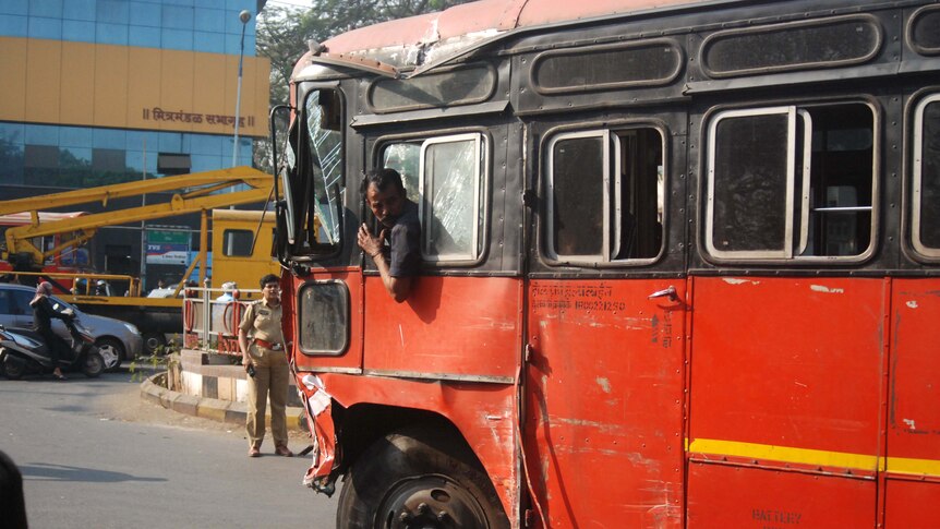 A man drives a bus after nine people were killed and dozens hurt when the bus's driver went on the rampage