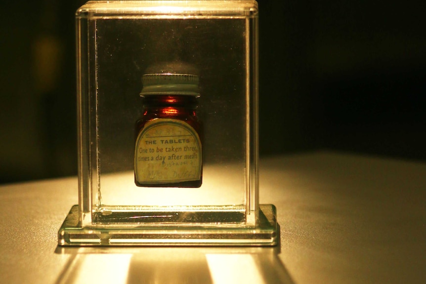A small medicine bottle encased in glass.