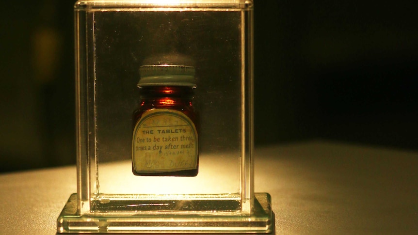 An old medicine bottle in a clear case.