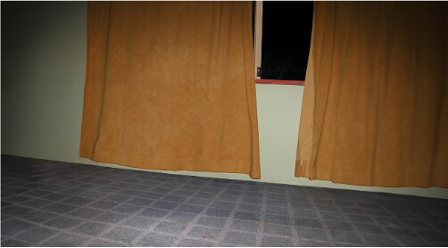 Yellow curtains dangle above a blue floor in a flash-photograph.