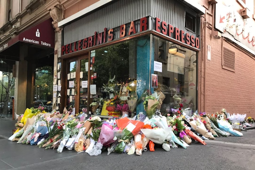 Several bouquets of flowers and bags of pasta sit outside Pellegrini's Espresso Bar.