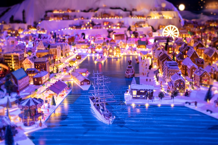 Le port d'une ville modèle en pain d'épice, avec un bateau en pain d'épice naviguant vers la mer. 