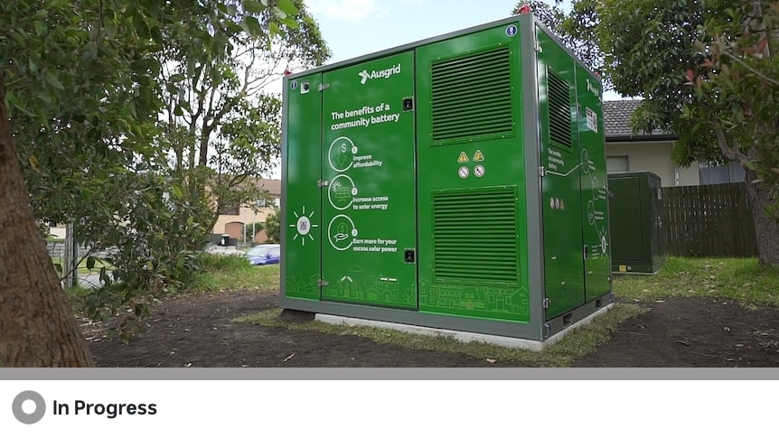 A large green box which is a community battery sitting on grass