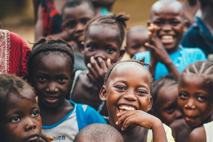 A close up of a group of children, one with a big smile.