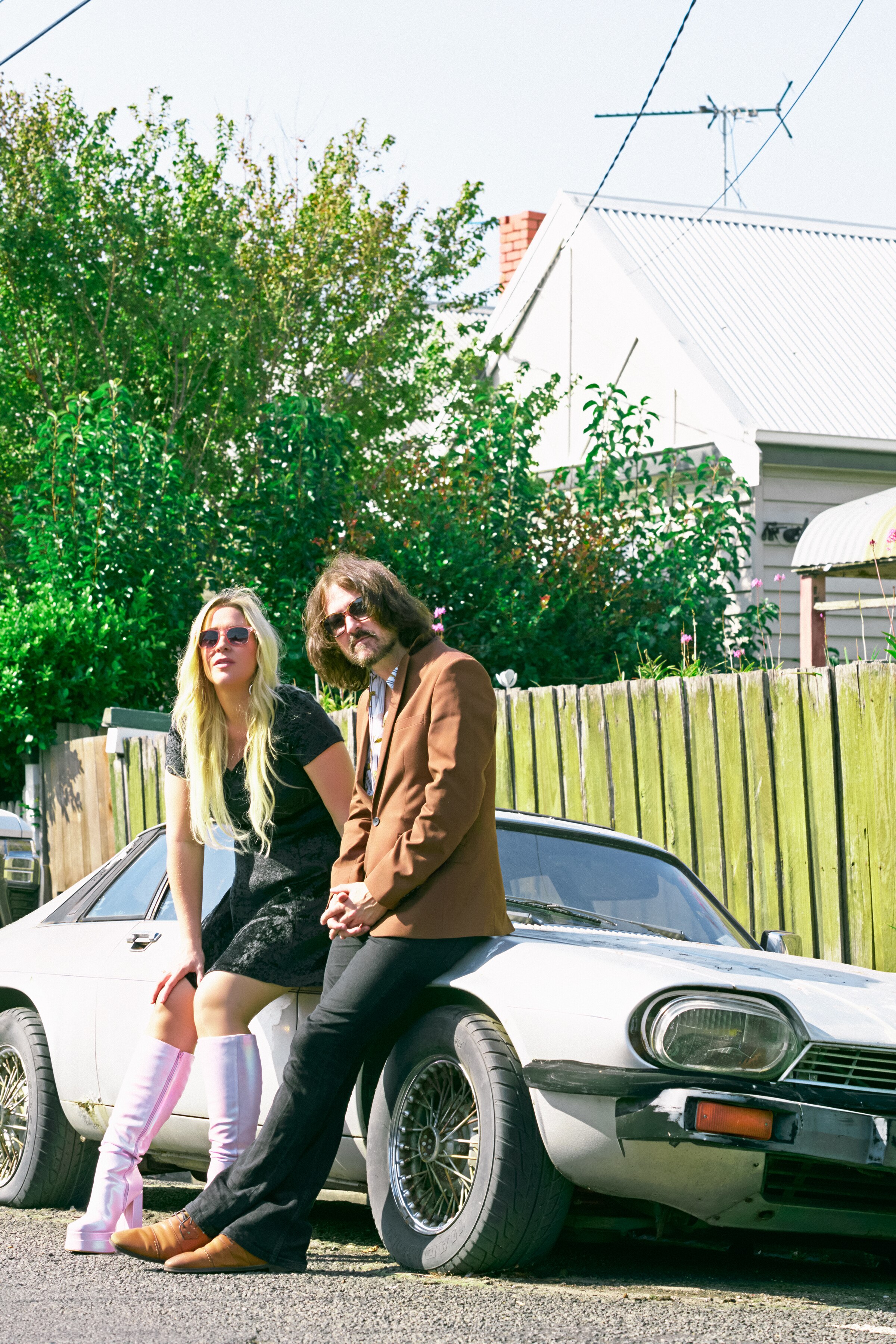 Picture of Country band The Pleasures leaning on a vintage car