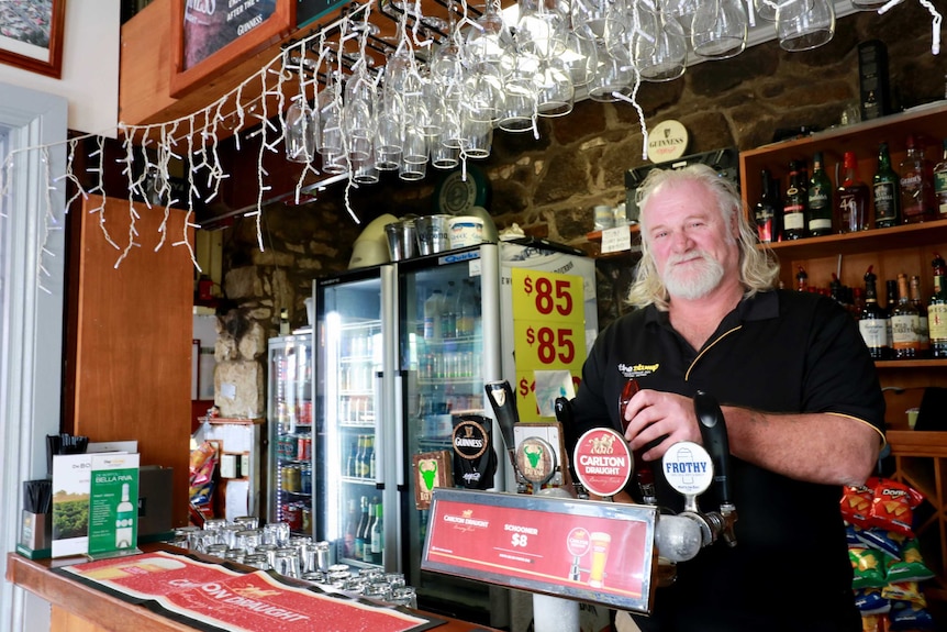 Barman Terry Miller stands behind the bar ready to pour drinks for the lunchtime crowd