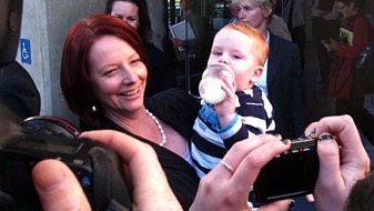 Prime Minister Julia Gillard hugs a baby (File image: George Roberts, ABC News)