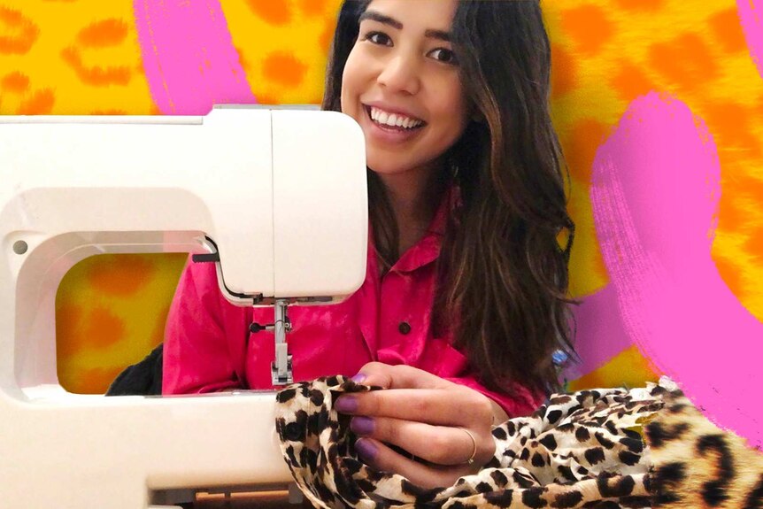 Tahlea Aualiitia sits behind a sewing machine, smiling as she sews some leopard print material
