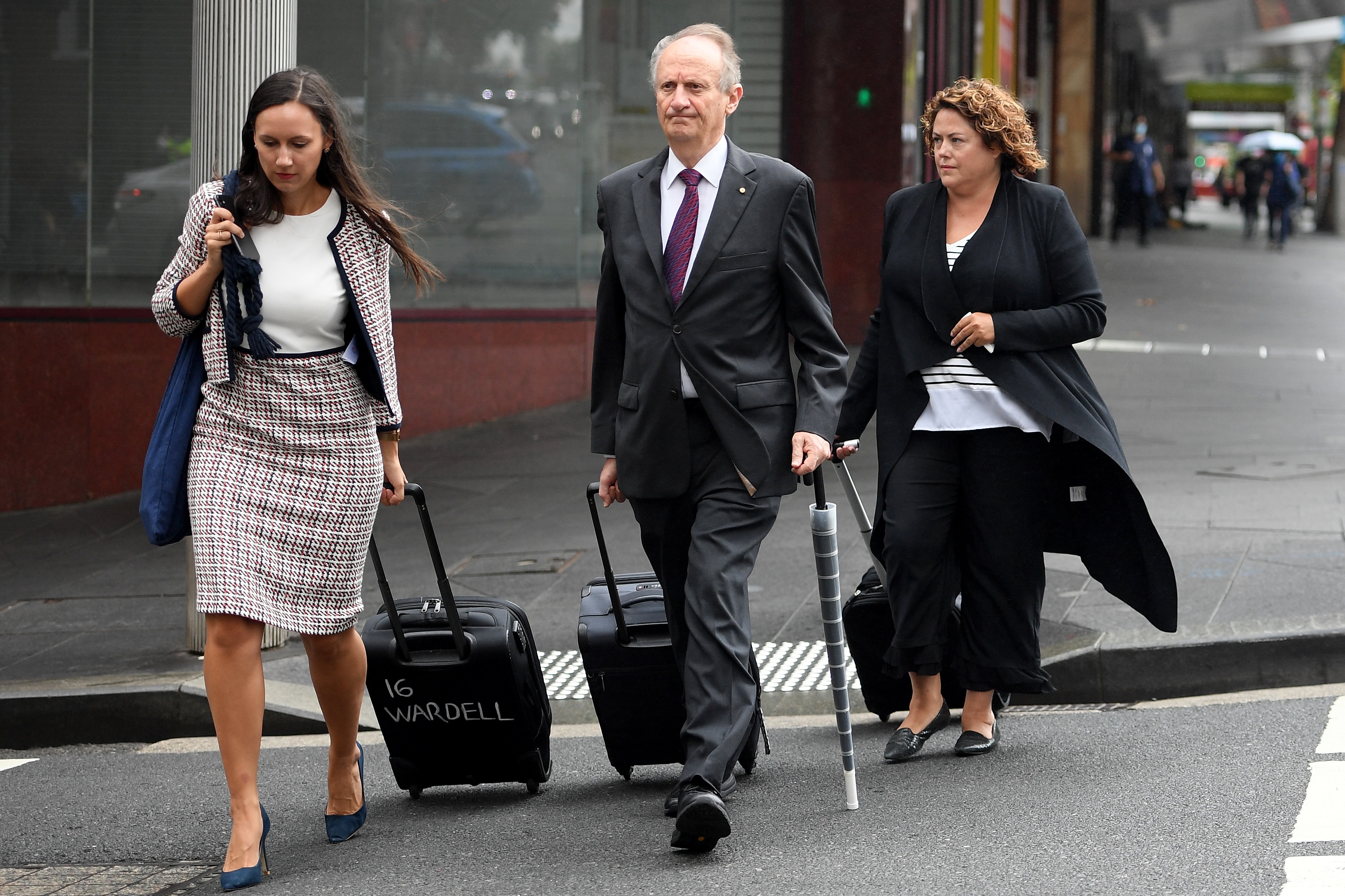 A man and two women crossing a road 