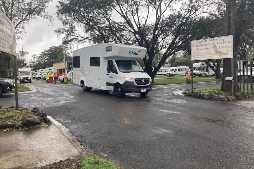 White campervan driving along a wet bitumen road