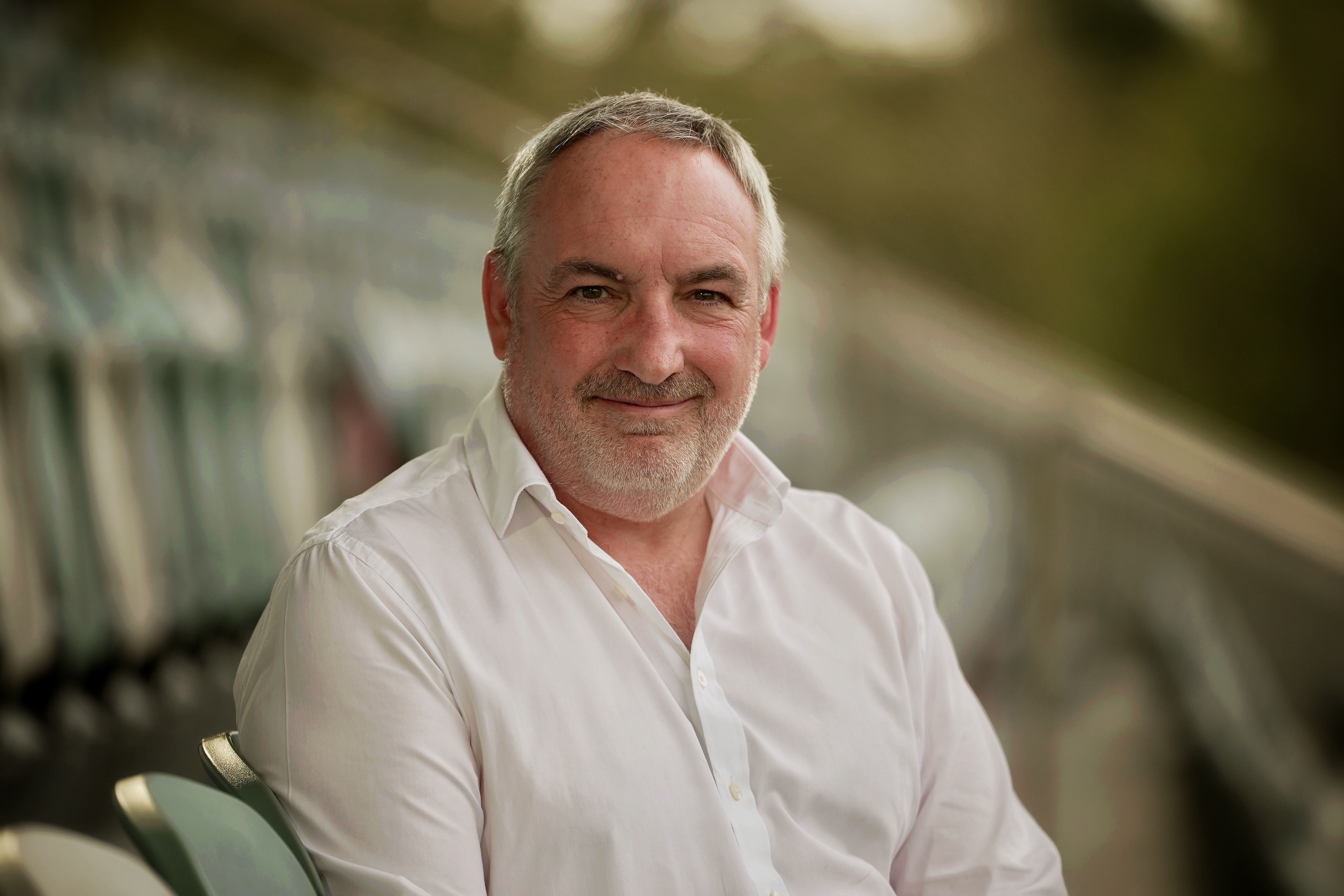 a man in a white shirt sitting in a grandstand