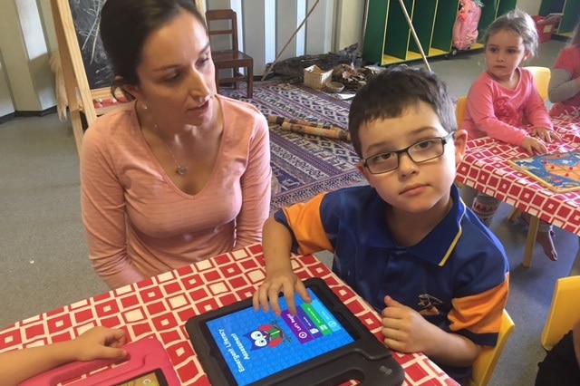 Karen Fraser watches her son Joshua use the app.