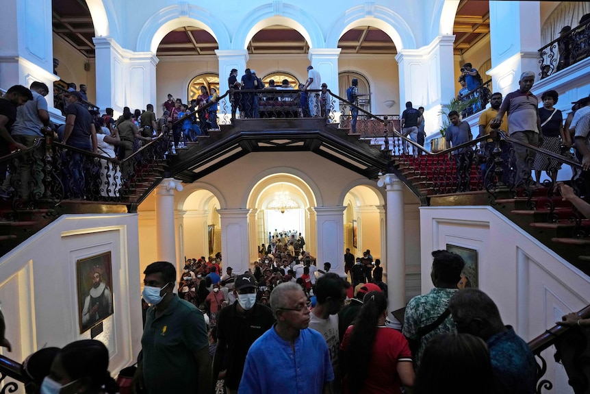 Crowds walk inside the Sri Lankan President's colonial style official residence.