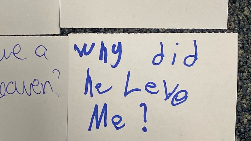 Image of a post-it note on the floor with a child's handwriting "why did he leve me?"