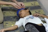 Syrian boy lies on the ground after alleged gas attack
