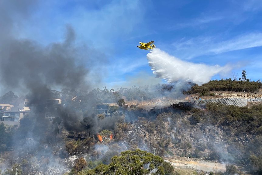 A helicopter is seen putting out a fire.