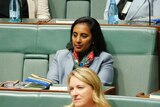 Michelle Ananda-Rajah is sitting down wearing a pale blue blazer and a multi-coloured scarf.