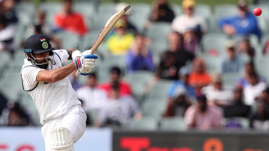 Virat Kohli plays a hook shot with his bat at a 45 degree angle up to the sky