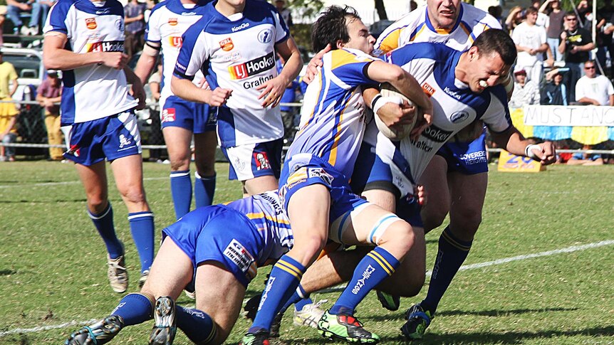 Murwillumbah Mustangs players tackle a Grafton Ghosts player during NRRRL grand final.
