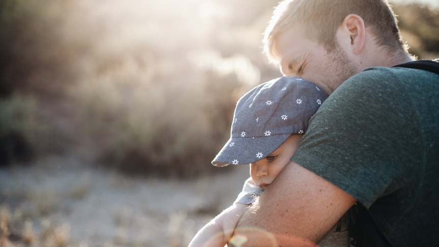 A man hugs a baby.