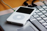 An Apple iPod sits on a laptop