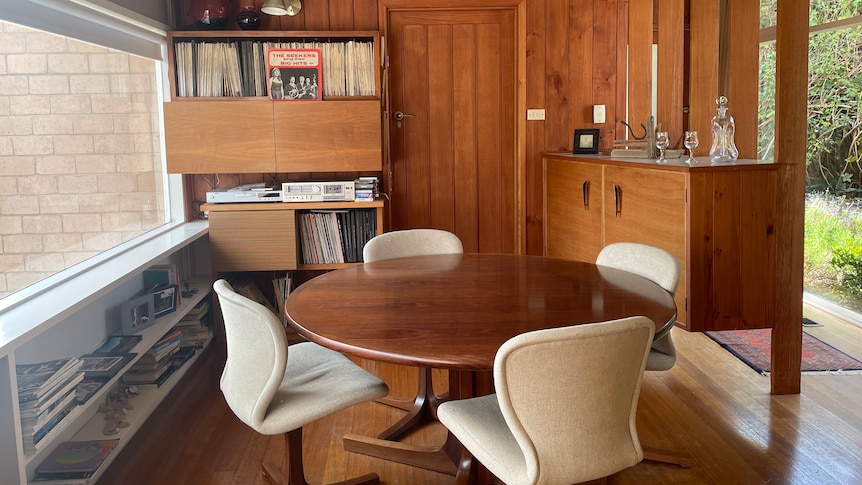 Wood panelled lounge with round table and swivel chair dining suite  