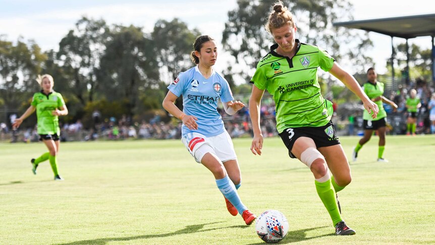 Two players compete for the ball in the W-League.