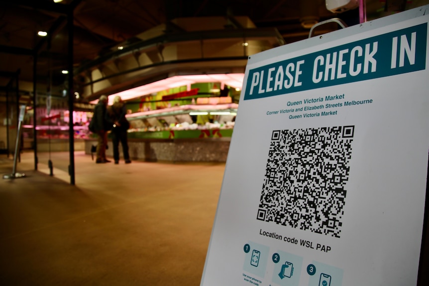A sign that says please check in with a QR code at Queen Victoria Market in Melbourne.