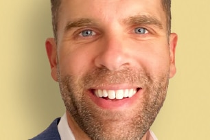 Brown haired man with blue eyes, smiling