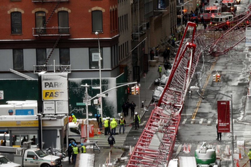 Emergency workers converge at the scene of a collapsed crane in a roadway in lower Manhattan.