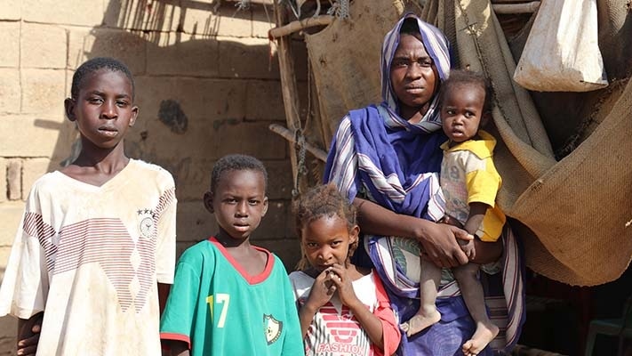 A Sudanese family including a mother holding a baby and three other children. 