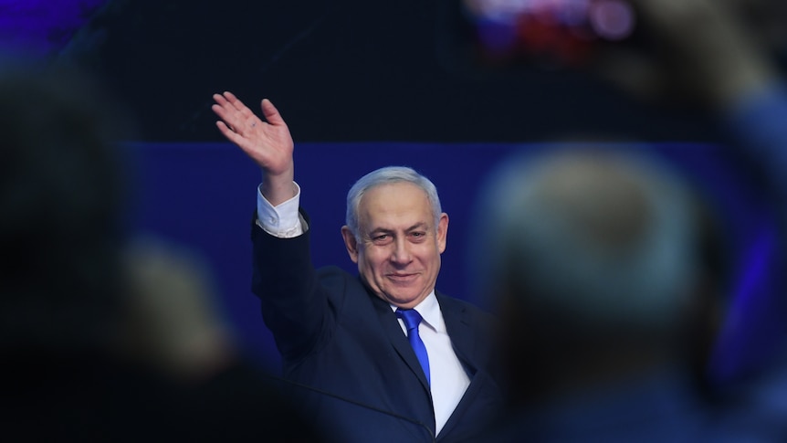 Israeli Prime Minister Benjamin Netanyahu gestures with his hand to a crowd