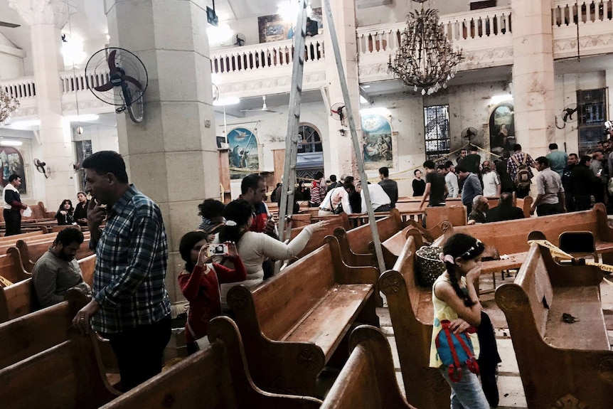 People survey the damage inside the St George coptic church in the Nile Delta town of Tanta, Egypt.