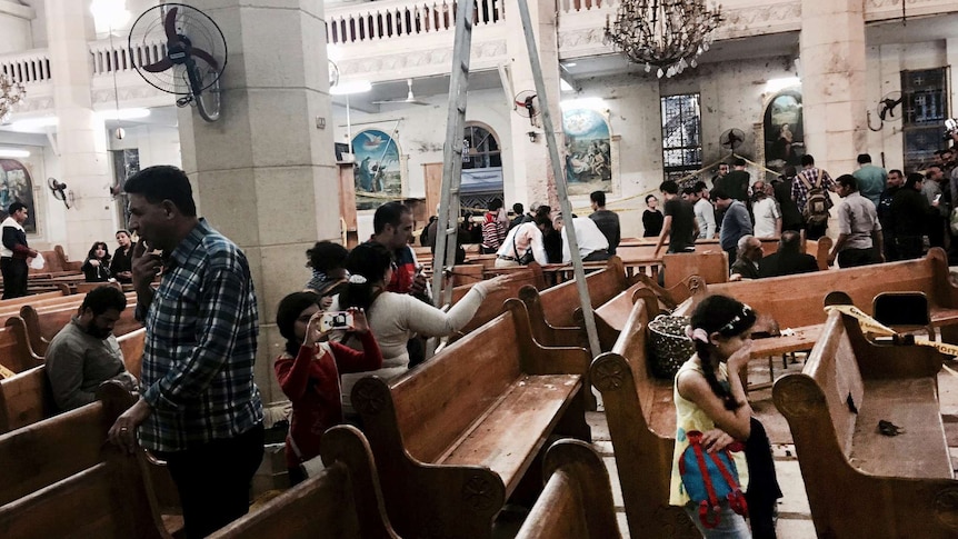 People survey the damage inside the St George coptic church in the Nile Delta town of Tanta, Egypt.