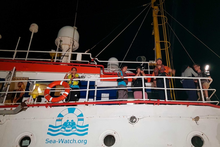 The Dutch-flagged Sea-Watch 3 ship docks docks, with several people on board looking out