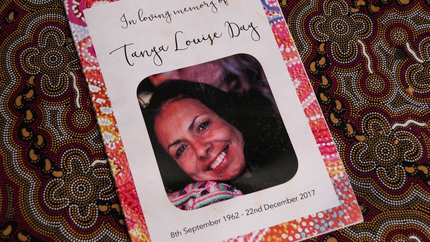 A funeral pamphlet, reading 'In Loving Memory,' Tanya Day's face, and the dates of her birth and death.