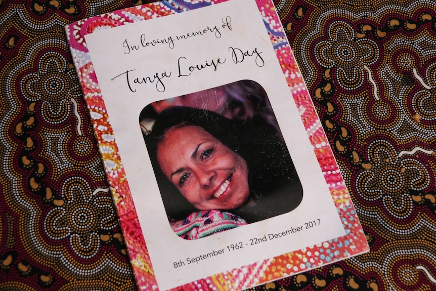A funeral pamphlet, reading 'In Loving Memory,' Tanya Day's face, and the dates of her birth and death.