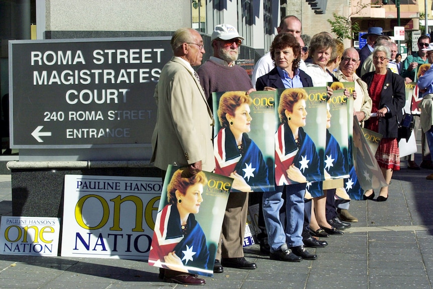 Pauline Hanson supporters holding One Nation signs and Australian flags wait outside the Brisbane Magistrates Court in 2001.