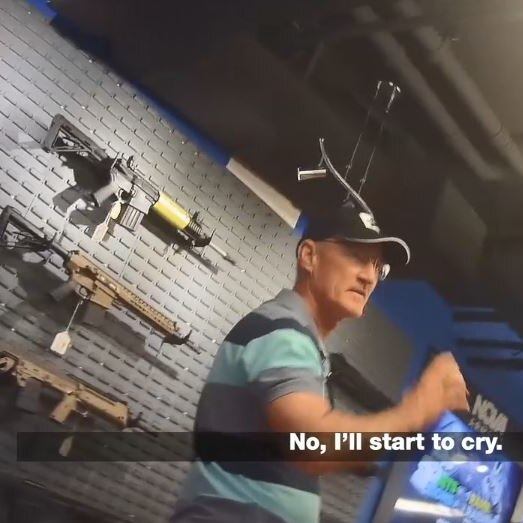 Steve Dickson, wearing a black cap and glasses, talks to someone at a gun store.