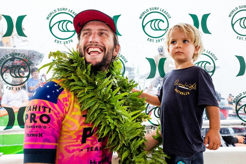 Owen Wright celebrates with his son Vali after winning the Tahiti Pro