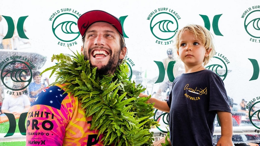 Owen Wright celebrates with his son Vali after winning the Tahiti Pro