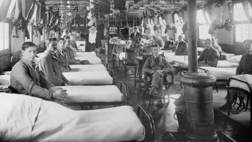 Soldiers lined up beside their beds in military hospital