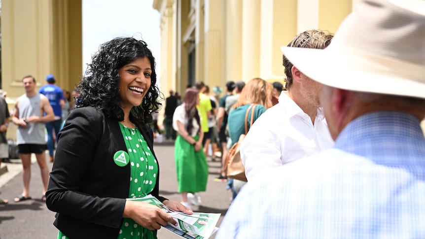 Samantha Ratnam smiles as she hands out flyers.