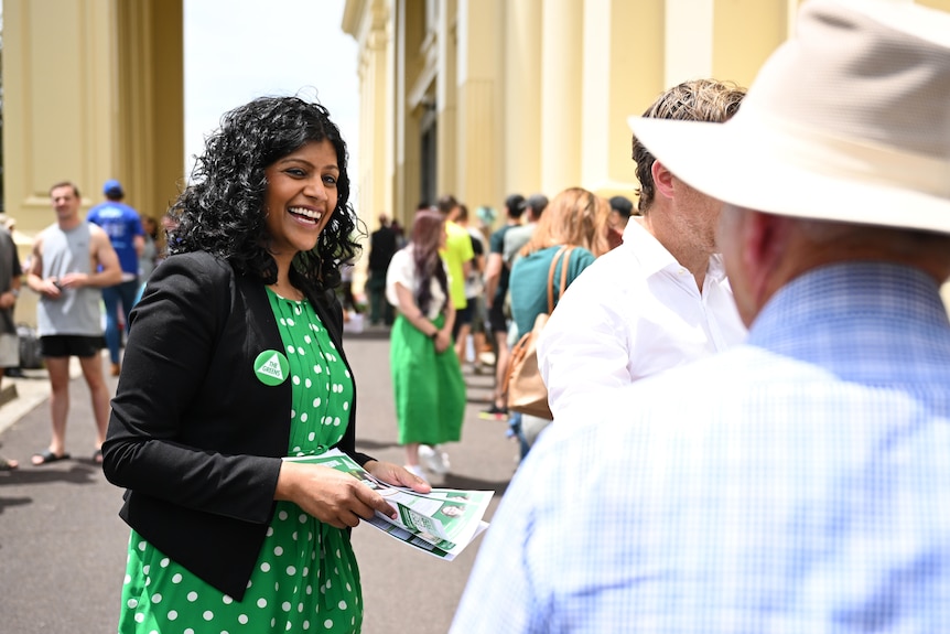 Samantha Ratnam smiles as she hands out flyers.