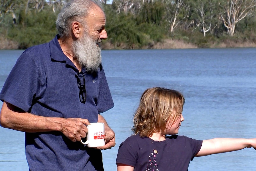 A man on a child against the backdrop of the River Murray.