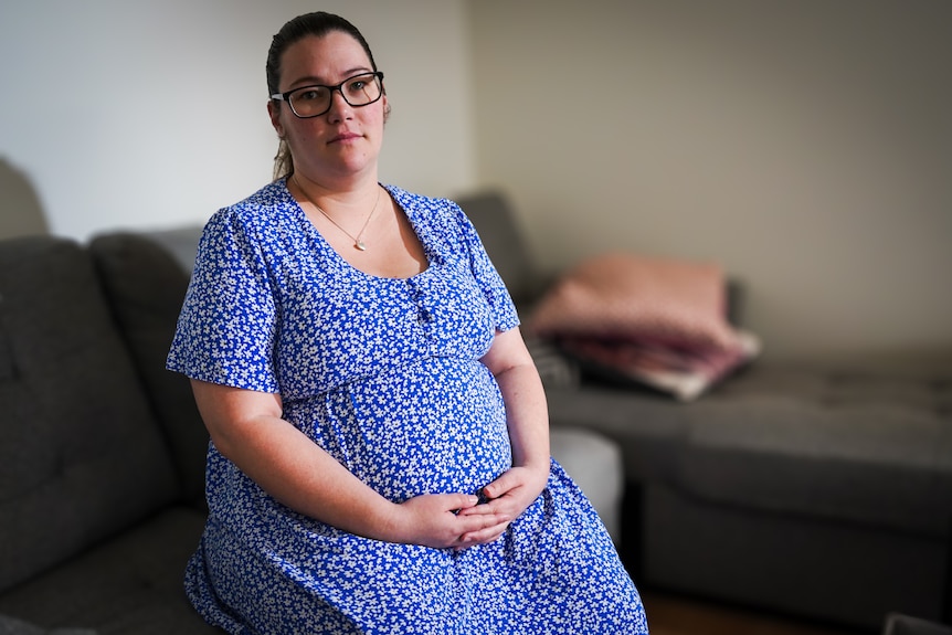A pregnant woman sitting on a couch.